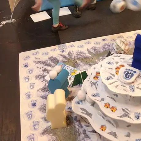 Action shot of my six year old daughter 'rolling' (kicking) the dice on Pegasus Spiele's giant demo set of Yeti at UK Games Expo 2016